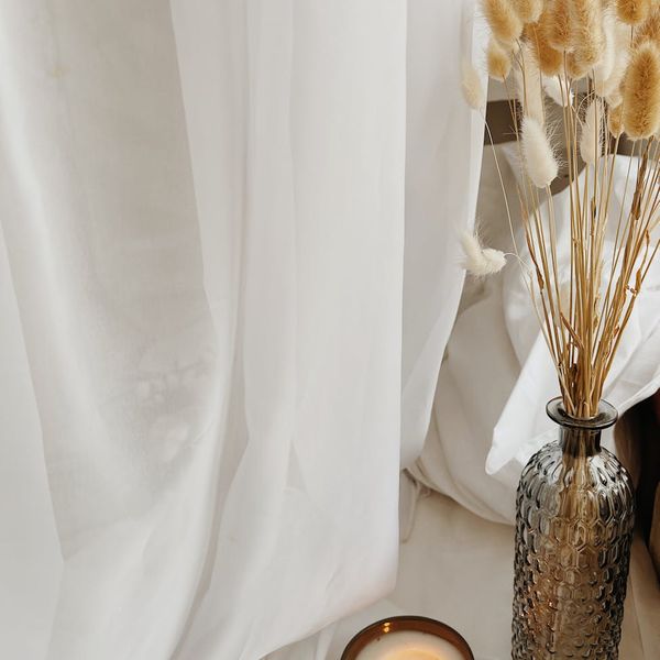A cozy and calm space prepared for yoga with a mat, candle, and soft light.